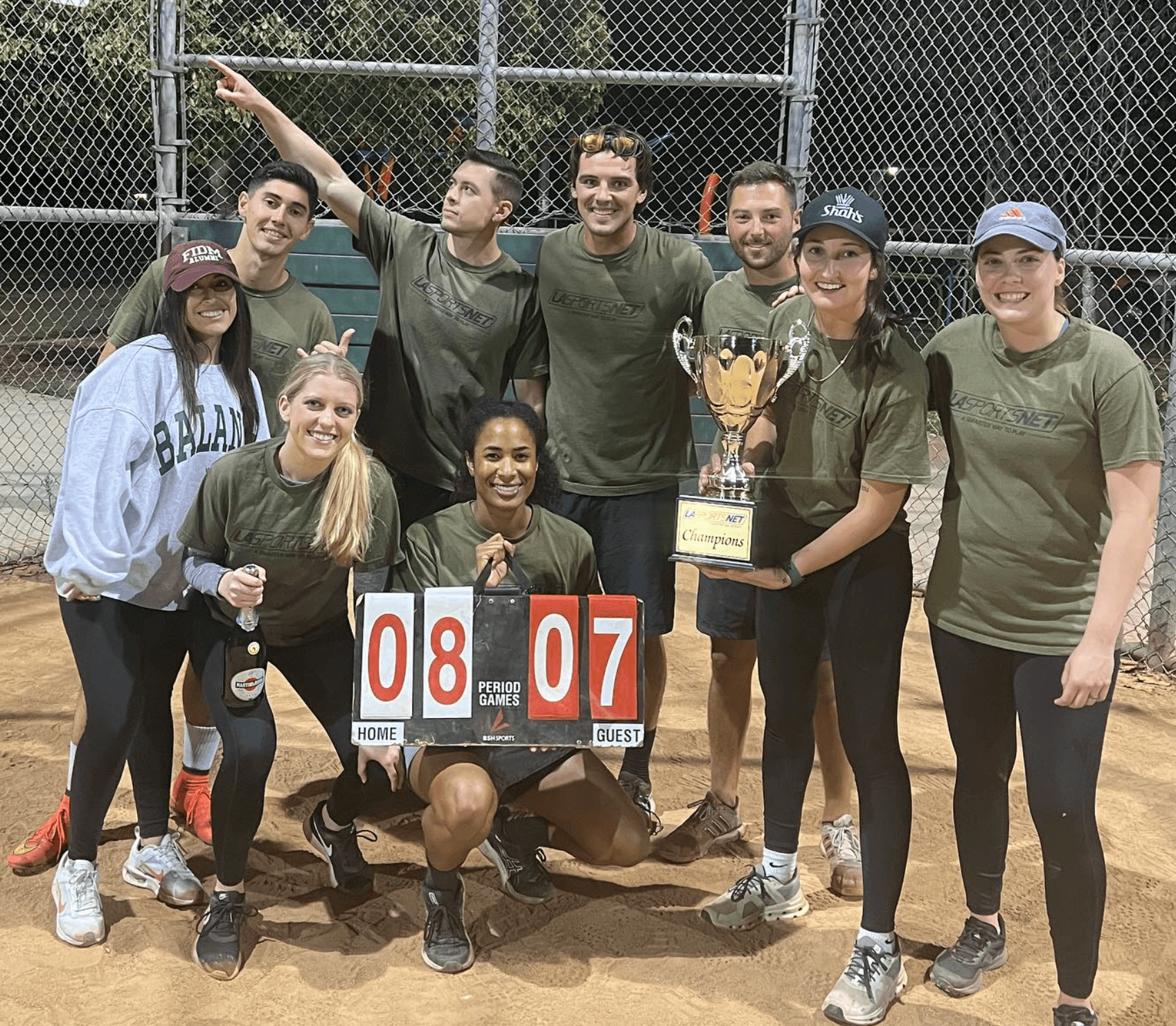 Two players fist-bumping on a basketball court, backlit by sunset